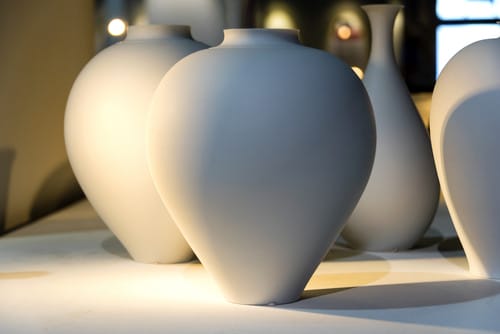 テーブルの上に置かれた白い花瓶のグループ。 テーブルの上に置かれた白い花瓶のグループ。