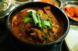 テーブルの上に肉と野菜が入った韓国シチューのボウル。 신의주_찹쌀순대_성균관대점_06