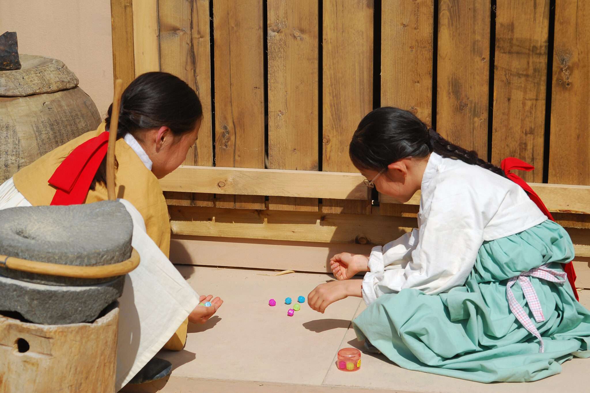 地面でゲームをする 2 人の韓国人の女の子。