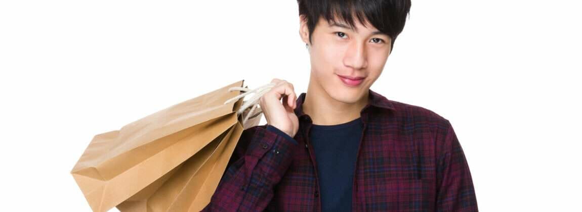 買い物袋を持った韓国から来たアジア系の若い男性。