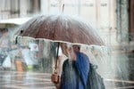 雨の中で傘をさす韓国人男性。