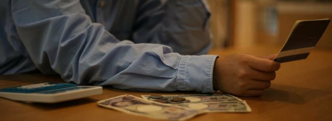 韓国でクレジットカードとお金を持ってテーブルに座っている男性。