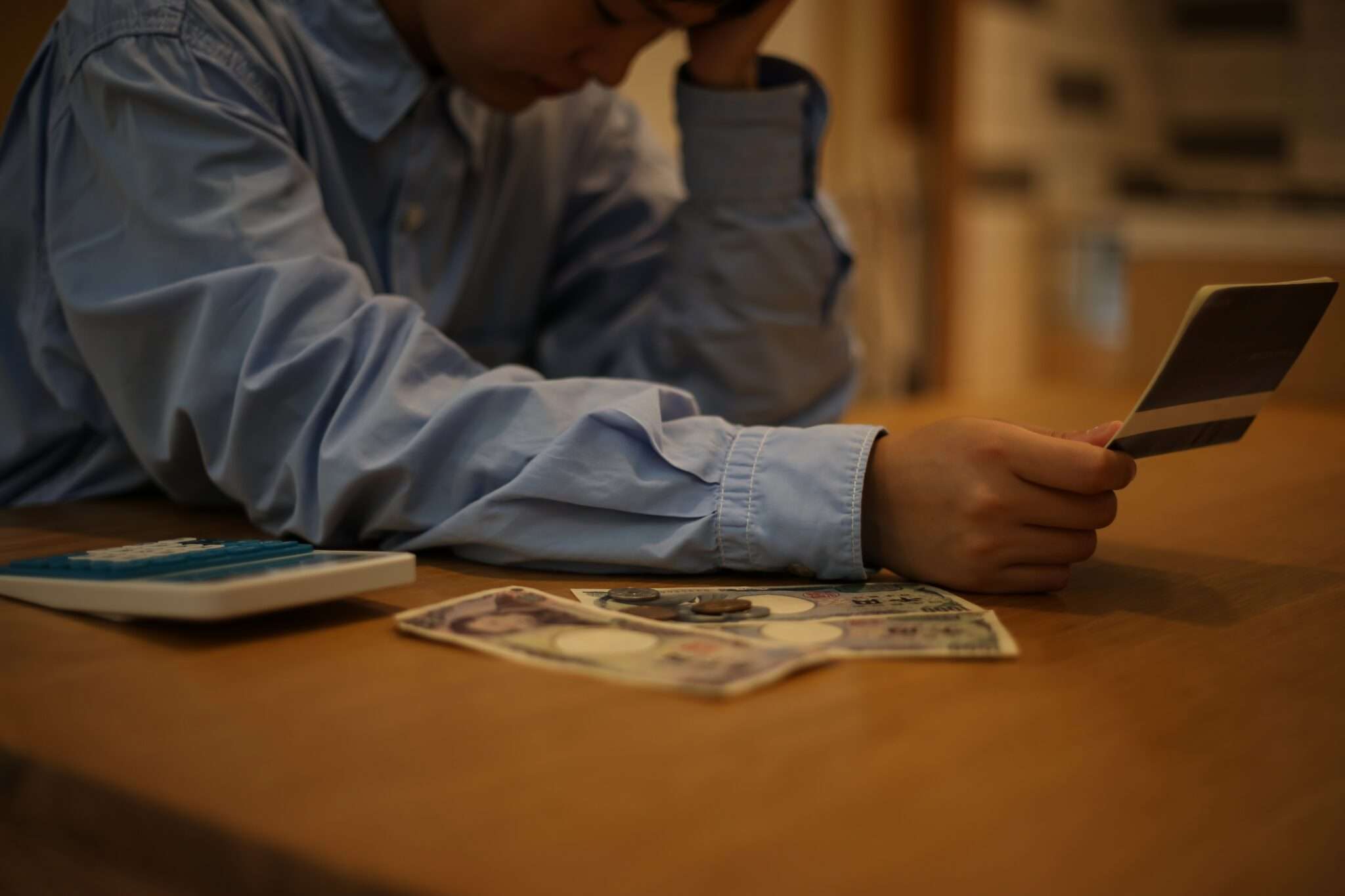 韓国でクレジットカードとお金を持ってテーブルに座っている男性。