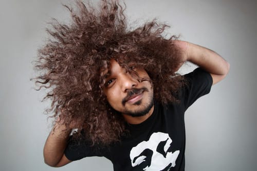 アフロのかつらをかぶった男性が韓国で写真を撮っている。