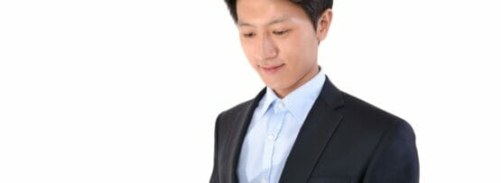 韓国人のスーツを着た男性がタブレット コンピューターを使用しています。