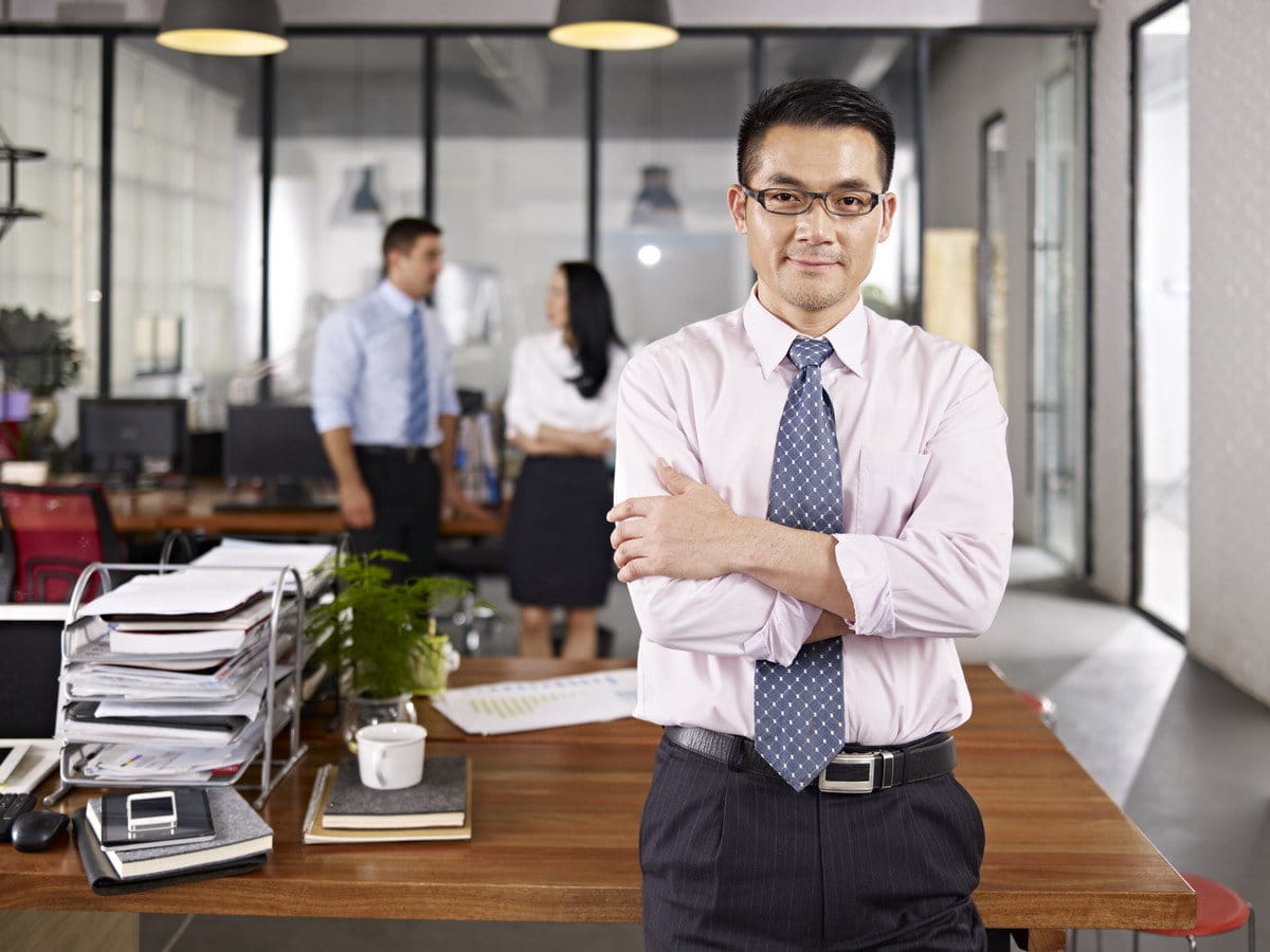 腕を組んでオフィスに立つ韓国人実業家。
