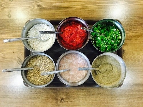 韓国の木製テーブルの上に、さまざまな食材が入った 5 つのボウル。