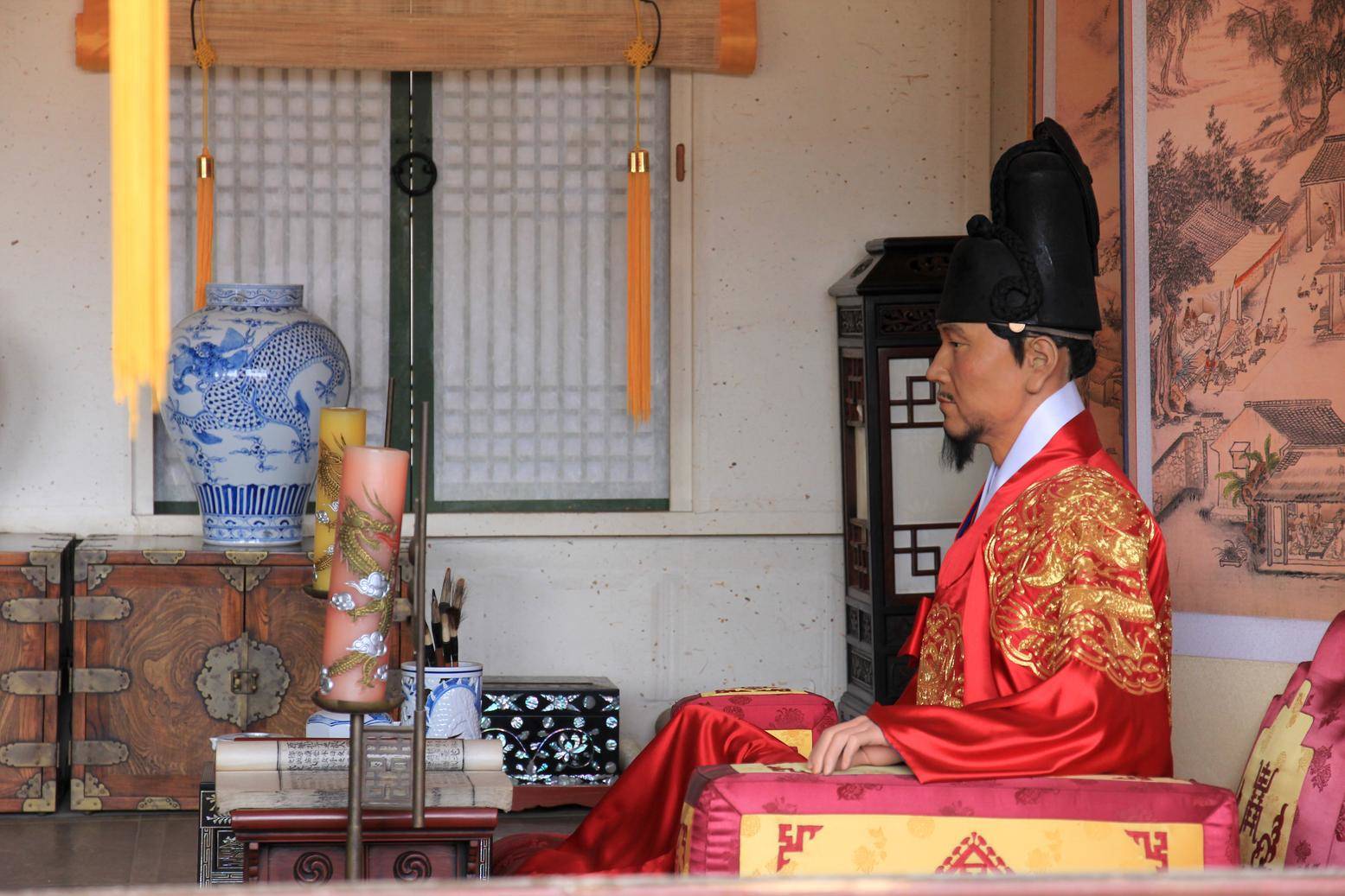 韓国で椅子に座る赤いローブを着た男性。