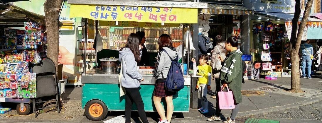 韓国の屋台の前に立つ人々のグループ。
