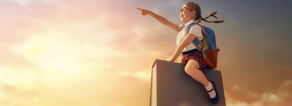 韓国の箱の上に座って空を指差す女の子。