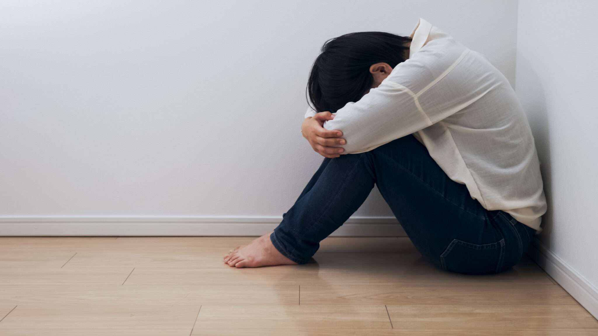 膝に手を置いて床に座る韓国人女性。