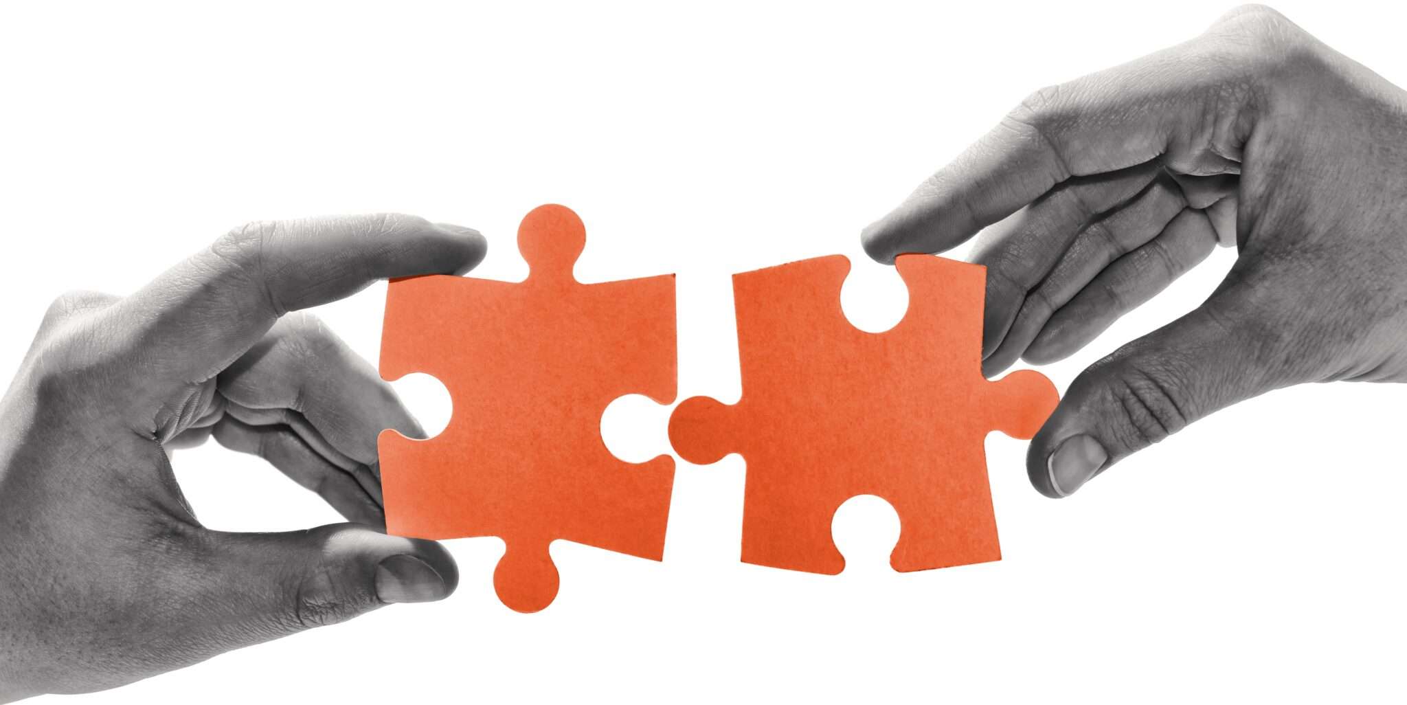 韓国でオレンジ色のジグソーパズルのピースを持つ両手。