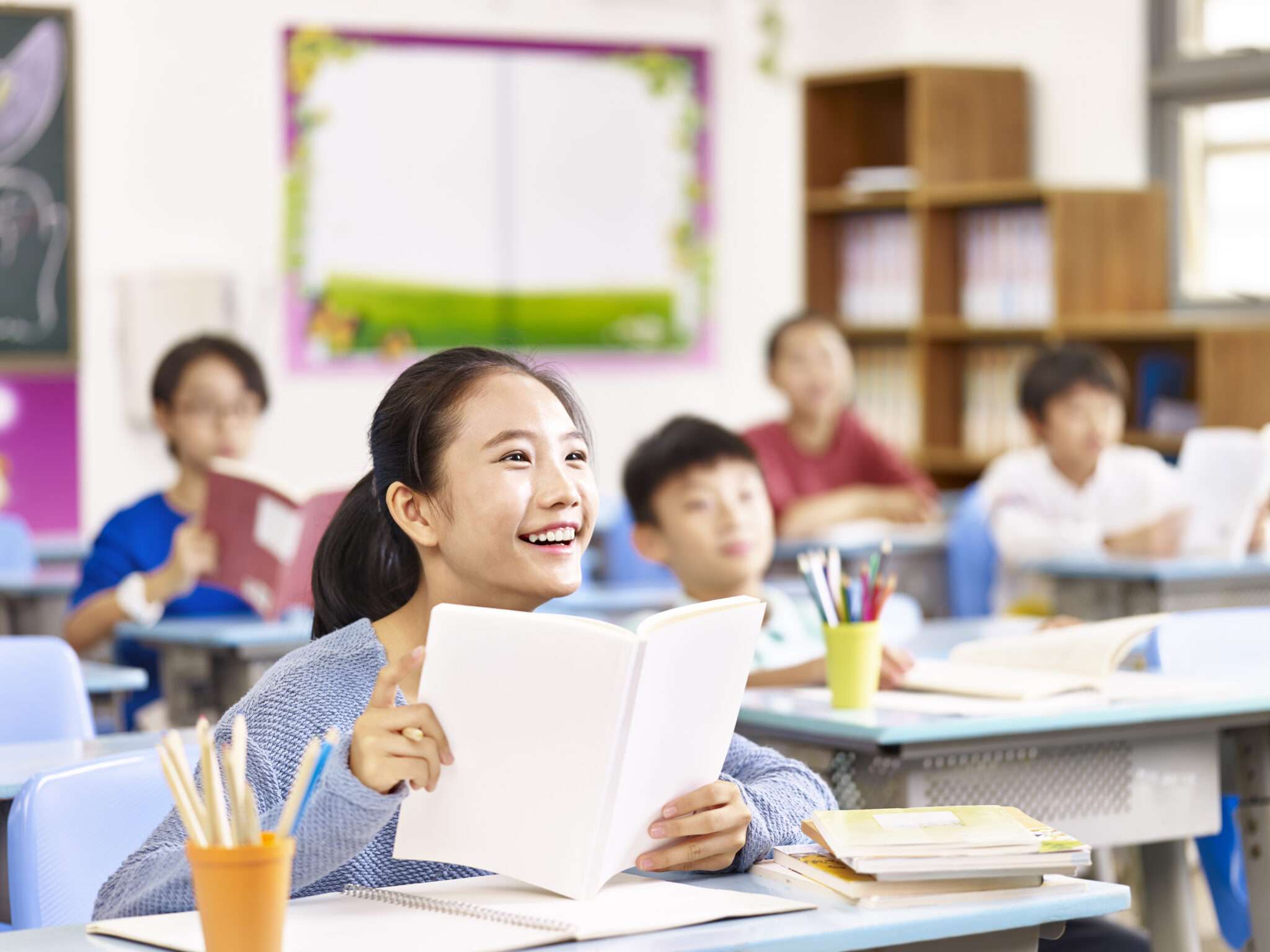 韓国語の教室で女性が本を読んでいます。
