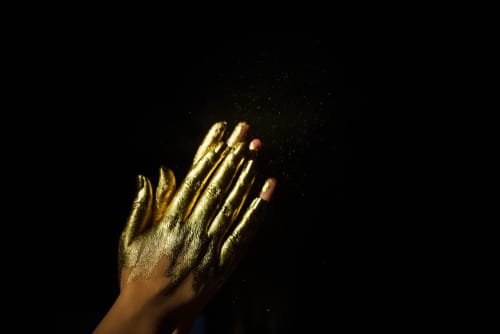 韓国の黒地に金色のペンキで覆われた女性の手。