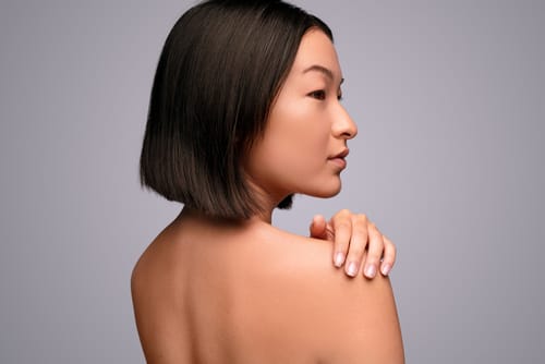 韓国から来たアジア系の若い女性が肩に手を置いてポーズをとっている。