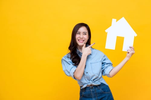 韓国の黄色の背景に家を持つアジアの若い女性。 韓国の黄色の背景に家を持つアジアの若い女性。