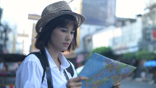 帽子をかぶった韓国の女の子が地図を見ている。 帽子をかぶった韓国の女の子が地図を見ている。