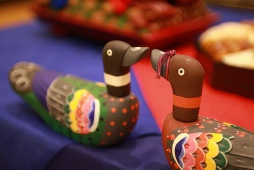 韓国から来た 2 匹の木彫りのアヒルがテーブルに座っています。