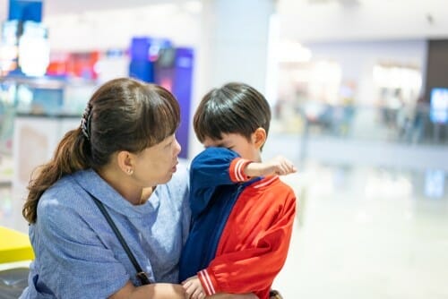 韓国（韓国）の空港で子供を抱いている女性。