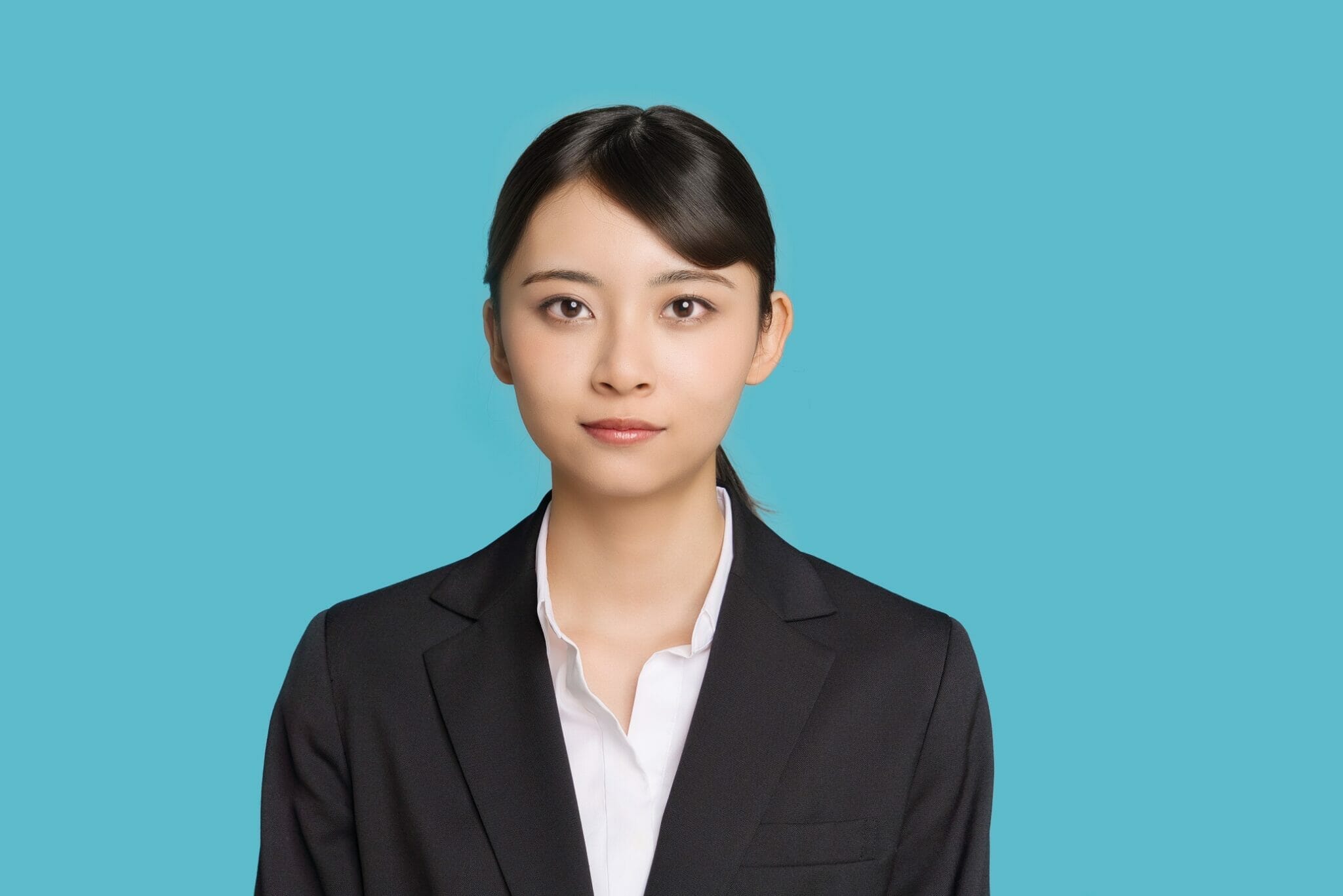 説明: 青い背景にビジネス スーツを着た日本人女性。