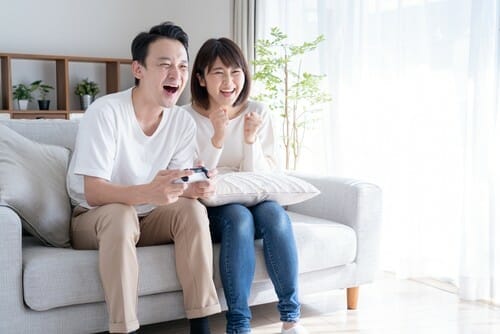 家でビデオゲームをしている若い韓国人カップル。