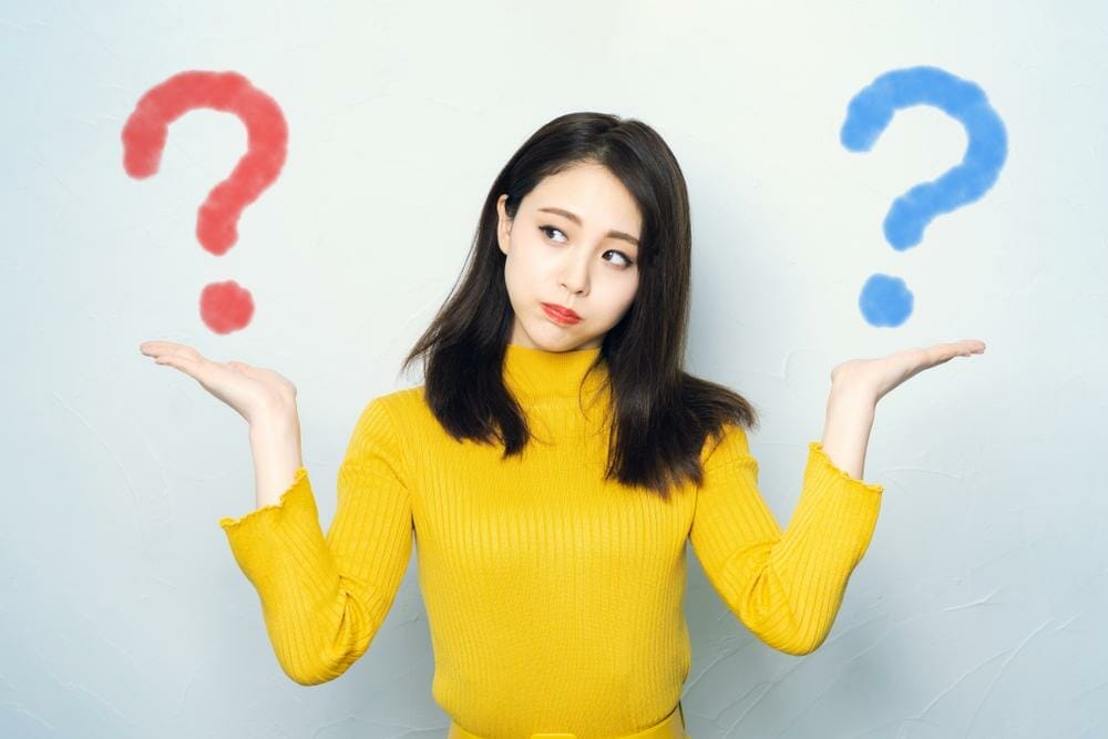 手に疑問符が付いた若い女性は、好奇心と驚きの感覚を表しています。