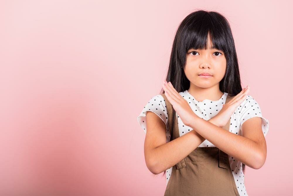 韓国のピンクの背景に手のジェスチャーをするアジアの若い女の子。