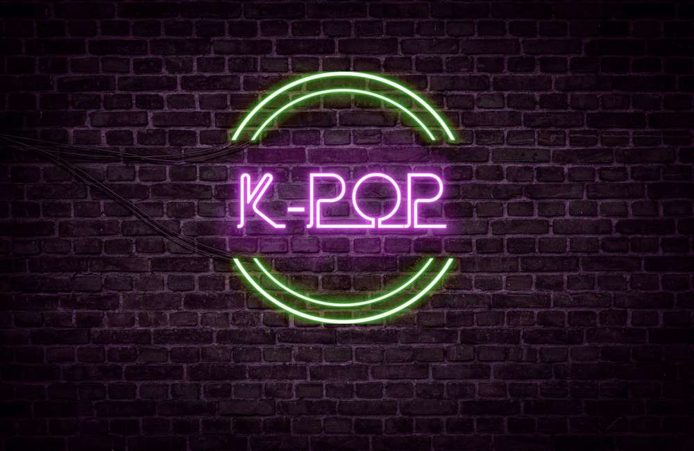 レンガの壁に「韓国 k-pop」と表示されたネオンサイン。 レンガの壁に「韓国 k-pop」と表示されたネオンサイン。