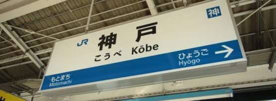 駅のプラットホームの標識には金属屋根の下に日本語と英語で「神戸」と道順が書かれており、旅行者に完全な案内を提供している。