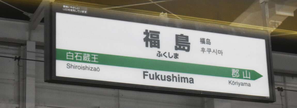 福島への方向を示す駅標識。日本語では「福島・郡山」と表示され、左側に白石蔵王、右側に郡山が描かれています。