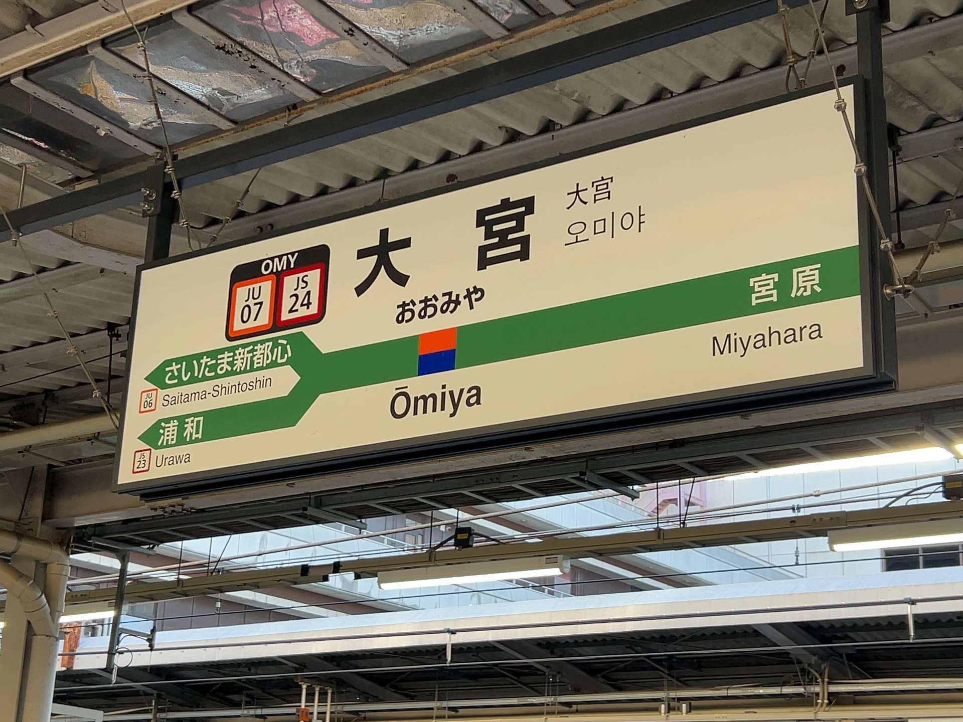 大宮の駅にある標識。駅コードは JU07 と JS24 で、大宮、さいたま新都心、浦和、宮原方面への方向を示しています。