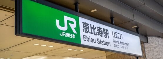 東京の恵比寿駅西口の看板。建物の天蓋の下に JR 東日本のロゴと場所の詳細が記載されています。近くには、個人向けの韓国語レッスンに興味のある方向けの韓国語教室マンツーマンもあります。.