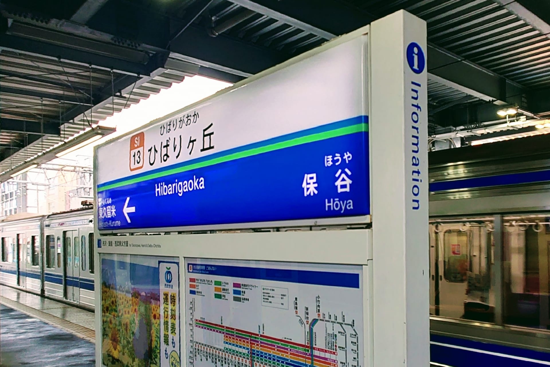 駅の標識には、ひばりヶ丘という駅名と、その上に案内記号、その下に地図が表示されており、列車は線路に沿って滑るように走っています。.