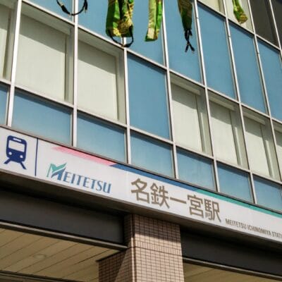 名鉄一宮駅の外観には、名鉄のロゴが目立つ日本語と英語の表記が設置されています。この賑やかな一宮の拠点では、窓が光を美しく反射し、旅行者から近くの韓国語教室マンマンツーについて問い合わせを受けることもあります。.