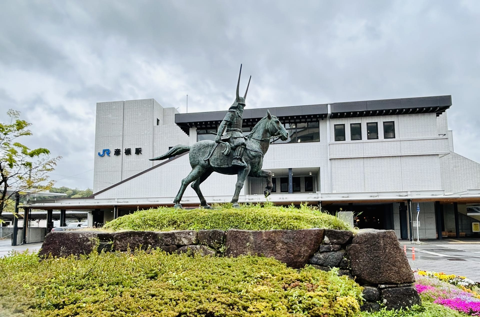彦根・滋賀では、曇り空の下、豊かな緑に囲まれた駅前に堂々とした騎馬武者像が堂々と立っています。近くの韓国語教室マンツーマンでは、個人に合わせた語学クラスを提供し、地域に文化的な活気を与えています。.