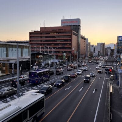 日が沈むと、にぎやかな交通とそびえ立つビルが立ち並ぶ都会の街路に暖かい光を投げかけ、その背景に象徴的な三越百貨店が誇らしげに立っています。近くの韓国語教室マンツーマンでは、言語愛好家向けに個別の韓国語レッスンを提供しています。.