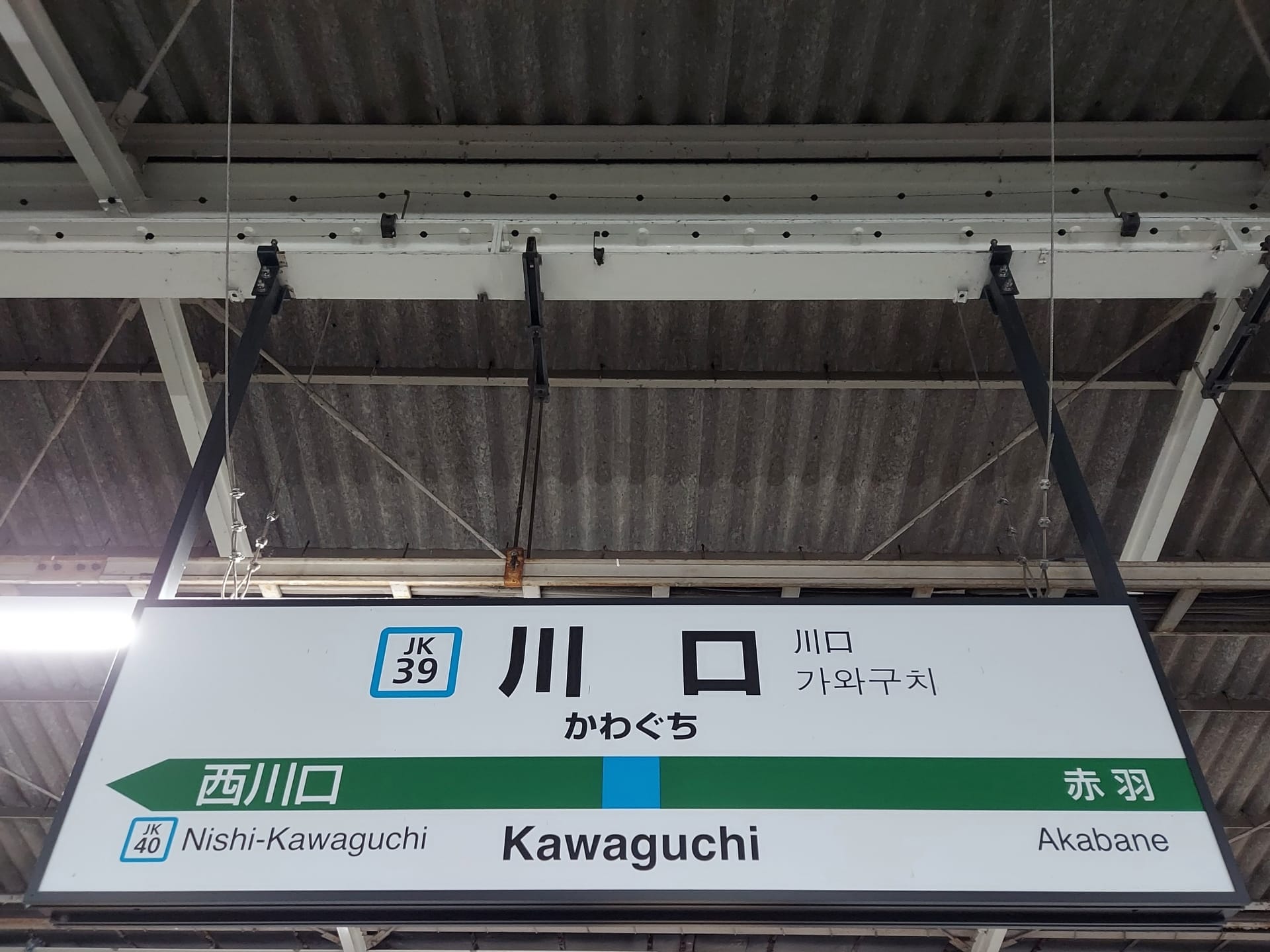 駅名標には「Kawaguchi」と日本語、英語、韓国語で上品に表示されています。川口行きは JK39、西川口行きは JK40 というホーム番号があり、赤羽方面へご案内します。近くにある韓国語教室マンツーマンのような多様な文化交流をさりげなく表しています。.