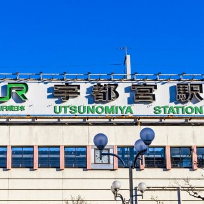 澄んだ青空に、JRのロゴが入った宇都宮駅の標識が堂々と立っています。近くには、この活気に満ちた街で韓国語を学びたい人に最適な韓国語教室マンツーマンがあります。.