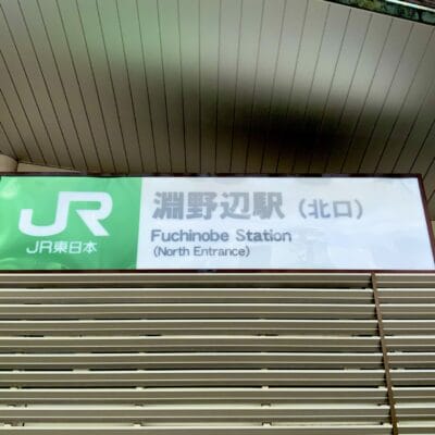 淵野辺駅北口の標識。モダンな建築を背景に、英語と日本語の文字が入った JR 東日本のロゴが描かれています。近くの韓国語教室マンツーマンでは、言語愛好家向けに個別の韓国語レッスンを提供しています。.