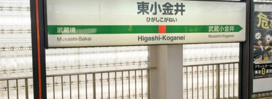 「東小金井」と書かれた駅の標識に「武蔵境」への道順が書かれています。標識は英語と日本語で書かれており、近くで韓国語のマンツーマンレッスンを探している人にも役立つガイドとなっています。.