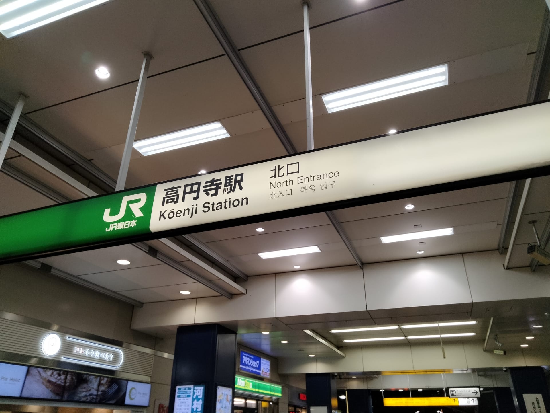 高円寺駅北口の標識は、日本語、英語、韓国語で書かれており、にぎやかな商業地区の上にひっそりと立っています。近くには、韓国語教室マンツーマンなどのさまざまな観光スポットがあり、語学スキルを向上させることができます。.