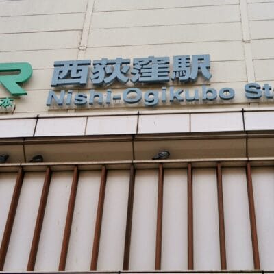 東京の西荻窪駅の標識。上に JR のロゴが付いています。標識の下の棚に鳩が止まっています。近くの韓国語教室マンツーマンは、西東京の活気ある西荻窪エリアで個人に合わせた学習体験を提供しています。.