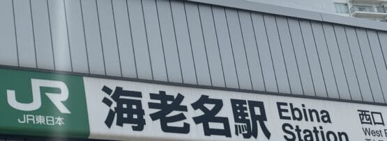 JR東日本海老名駅西口の標識。背景に建物があり、近くには個別の韓国語レッスンを提供する韓国語教室マンツーマンがある。.