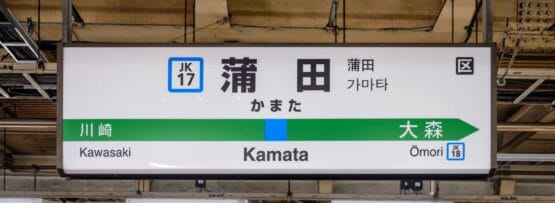 駅の案内板には、川崎、蒲田、大森方面への路線が日本語、韓国語、英語で表示されています。天井と照明が、賑やかな風景の上に魅力的な雰囲気を醸し出しています。.