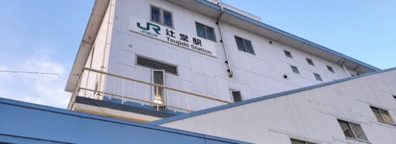 辻堂にある辻堂駅舎の外観。澄み切った青空の下、白い壁に駅名とJRのロゴが優雅に表示されている。.