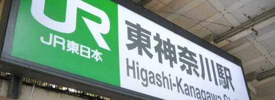 JR東日本のロゴが入った東神奈川駅の標識。日本語と英語の文字が表示されている。.