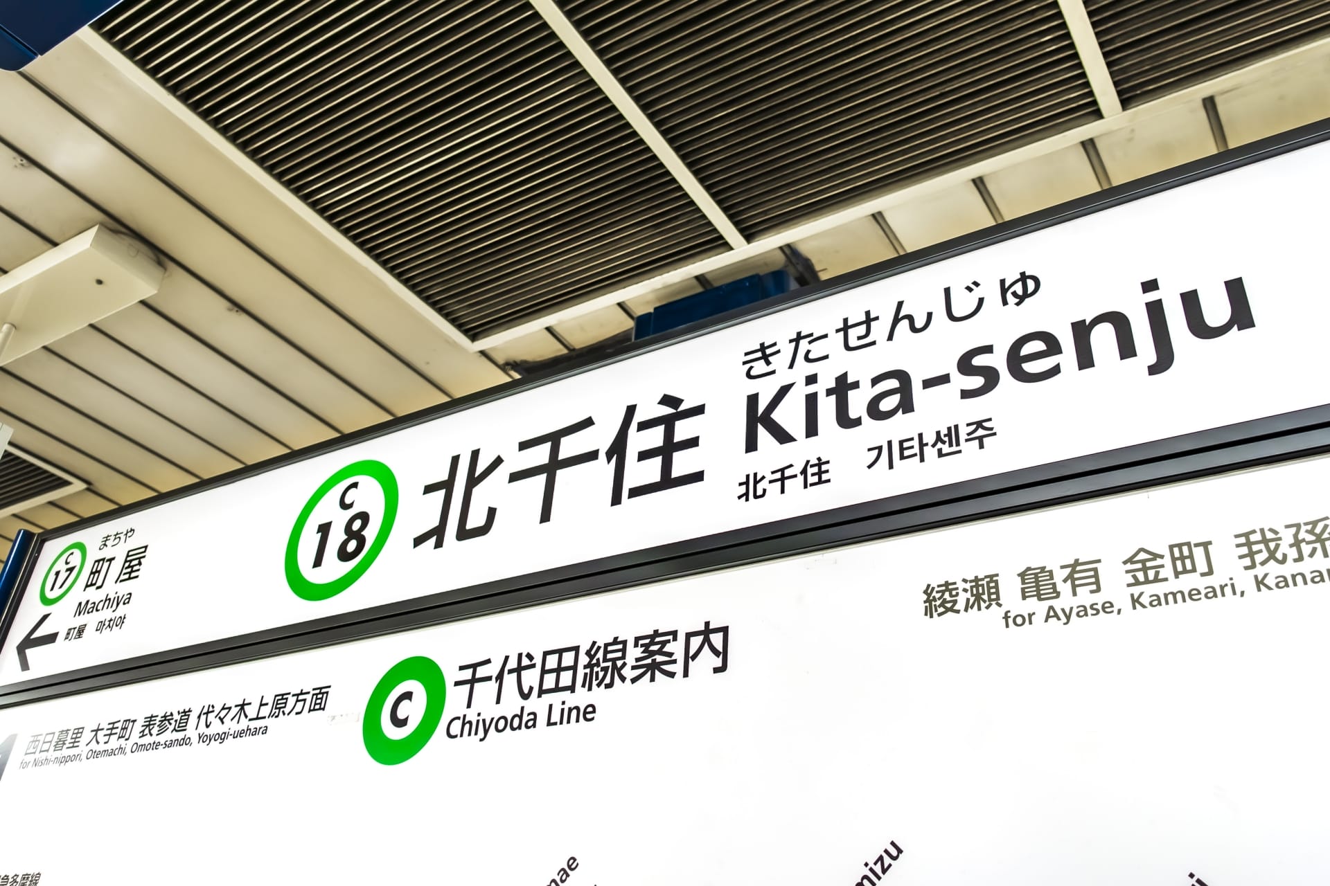 東京の千代田線北千住駅の標識には駅番号C18とC17が記されており、日本語、ハングル、英語の文字が表示されている。近くの韓国語教室マンマンツーセッションに向かう人に最適です。.
