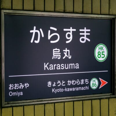 地下鉄烏丸駅には、大宮と京都河原町への方向を示す標識があり、駅番号HK 85が明確に表示されています。.