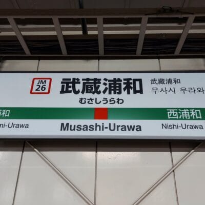 武蔵浦和の駅名標には、日本語、韓国語、英語で「Musashi-Urawa」と表記されています。方向矢印は旅行者を南浦和 (左) と西浦和 (右) に案内しており、韓国語教室マンツーマンに向かう人やこの地域を探索する人に最適です。.