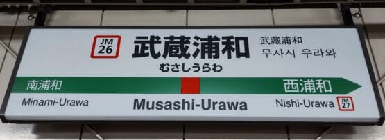 武蔵浦和の駅名標には、日本語、韓国語、英語で「Musashi-Urawa」と表記されています。方向矢印は旅行者を南浦和 (左) と西浦和 (右) に案内しており、韓国語教室マンツーマンに向かう人やこの地域を探索する人に最適です。.